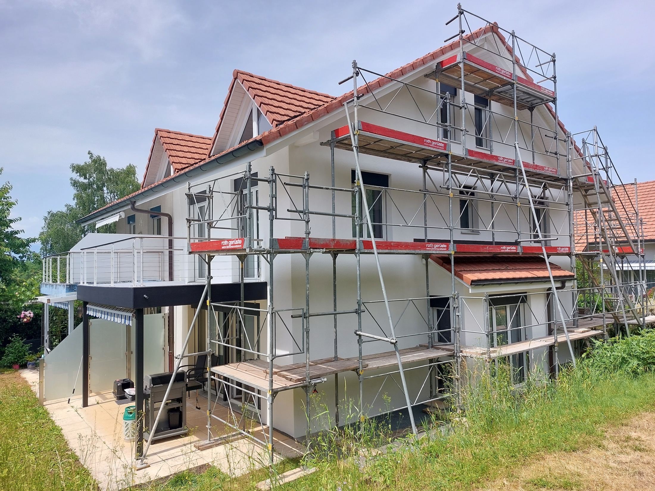 Eingerüstetes Einfamilienhaus während des Aussenanstrichs
